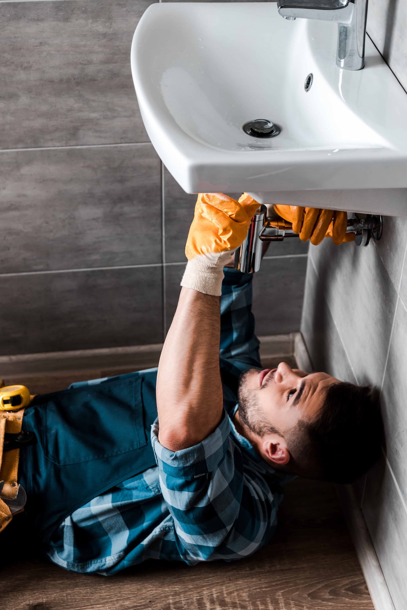 Plumber working under sink